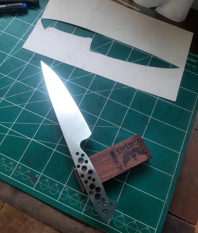 lâmina de faca artesanal com molde de papel para traçado do cabo em madeira