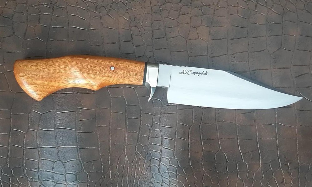 Faca artesanal Runefall com cabo em madeira nobre e lâmina assinada AS Campagnholi, detalhe do rebite e guarda