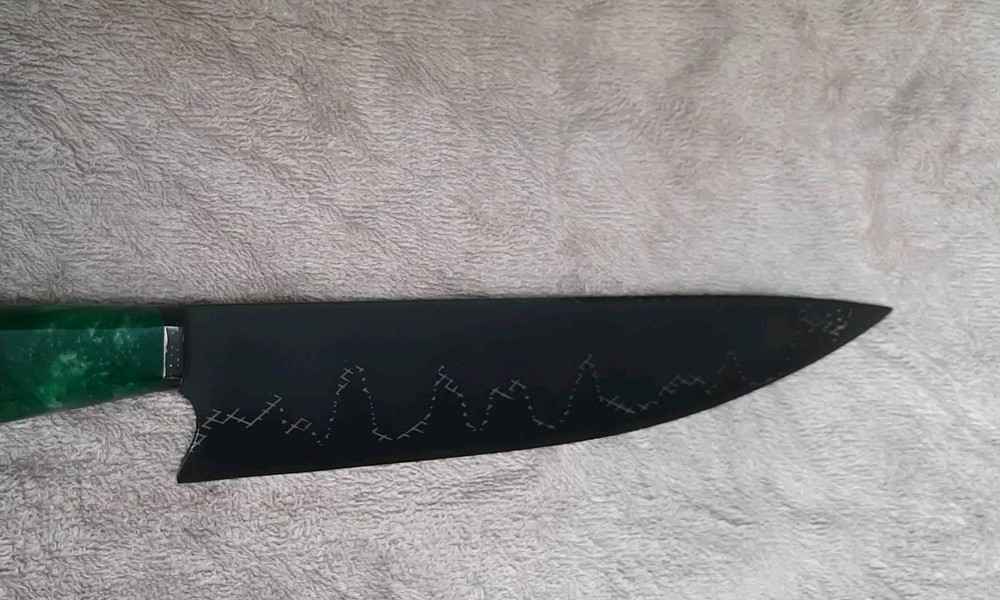 "Faca artesanal Runefall com lâmina em acabamento preto e gravação decorativa, cabo em resina verde e madeira nobre"