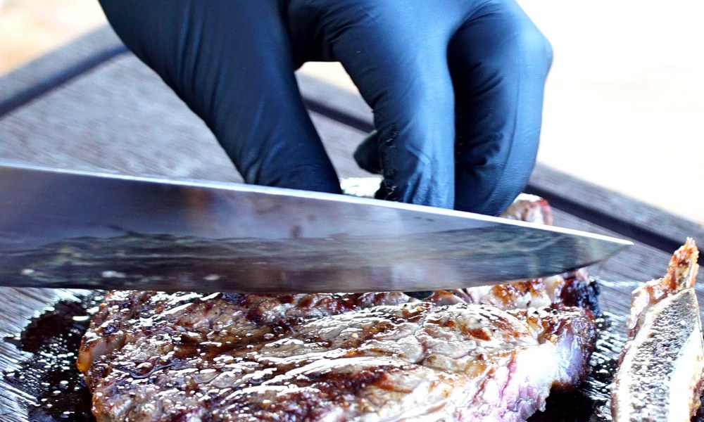 Faca fatiando carne no churrasco